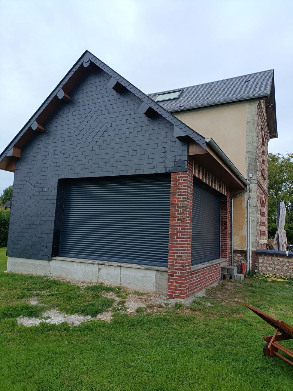 Extension maçonnée avec pignon en ardoise, accolée à une maison normande en silex et brique
