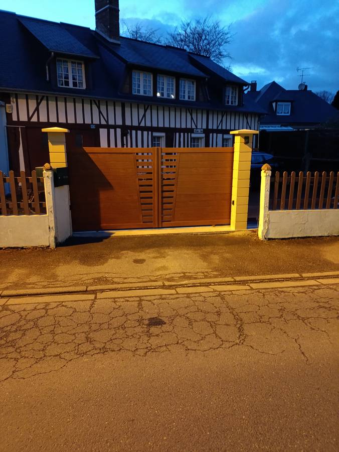 Piliers et portail devant une longère à colombages